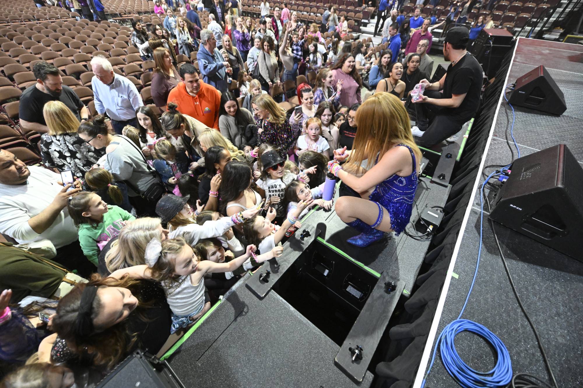 Melody Ebner greeting young fans at the edge of the stage