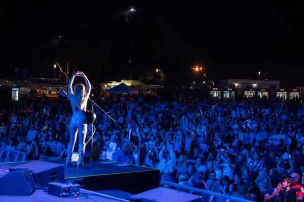 Melody Ebner making a heart to a huge crowd at night