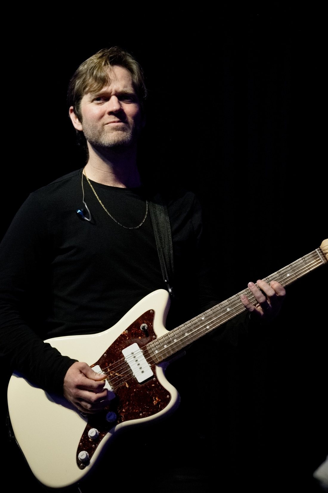 Guitarist with a white offset guitar