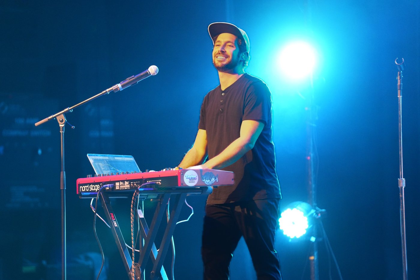 Keyboard player smiling behind a red keyboard