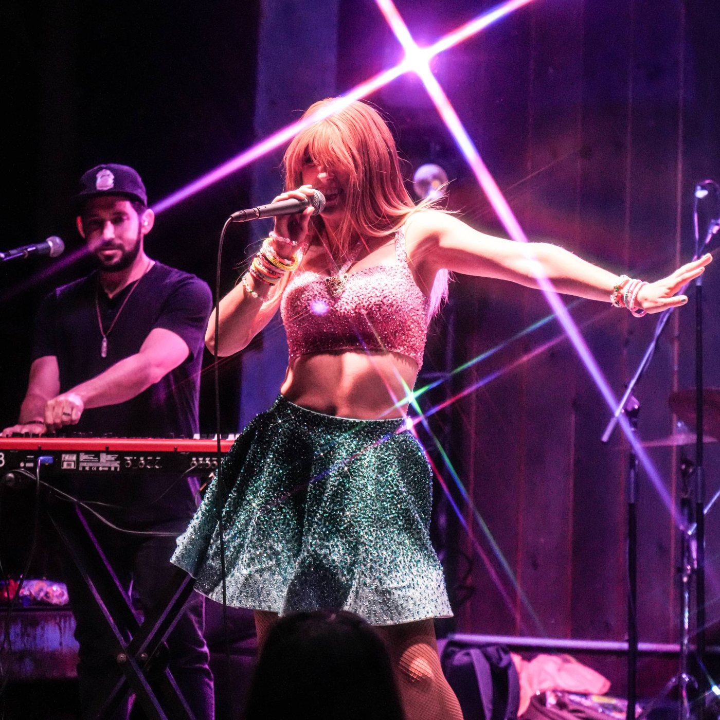 Melody Ebner performing in a pink top and sparkling skirt
