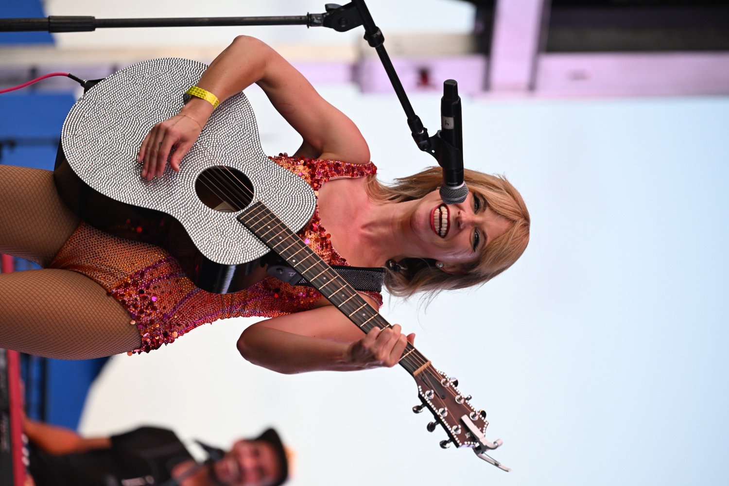 Melody Ebner smiling with a rhinestone acoustic guitar